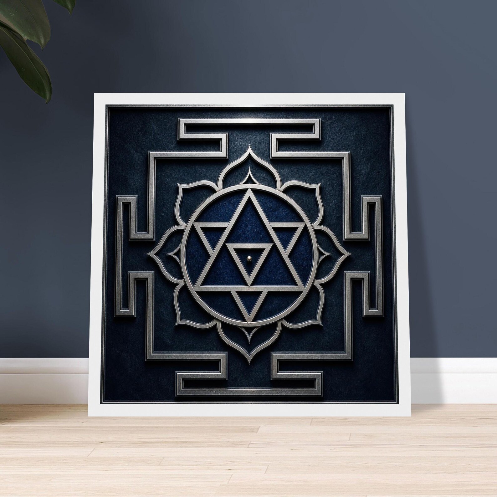 Shiva Yantra print in a white frame leaning against a deep blue wall